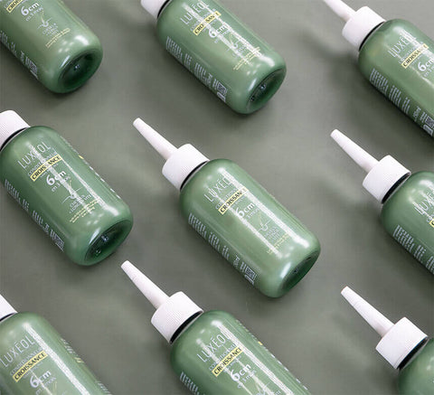 Flat lay of multiple Luxéol Growth Conditioner bottles for range consistency.