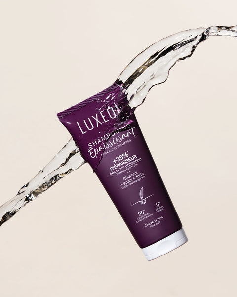 Lilla Luxeol juuksehooldustooted veesplashi taustal beežil pinnal