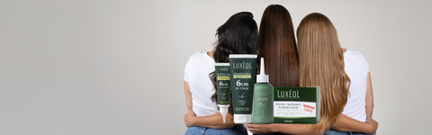 Kolm naist Luxeol juuksehooldustoodetega enda ees neutraalses taustas
